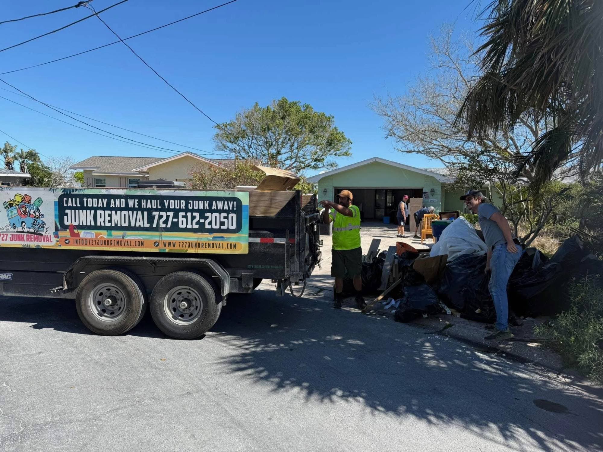 727 Junk Removal crew loading storm debris onto the trailer in Pinellas County